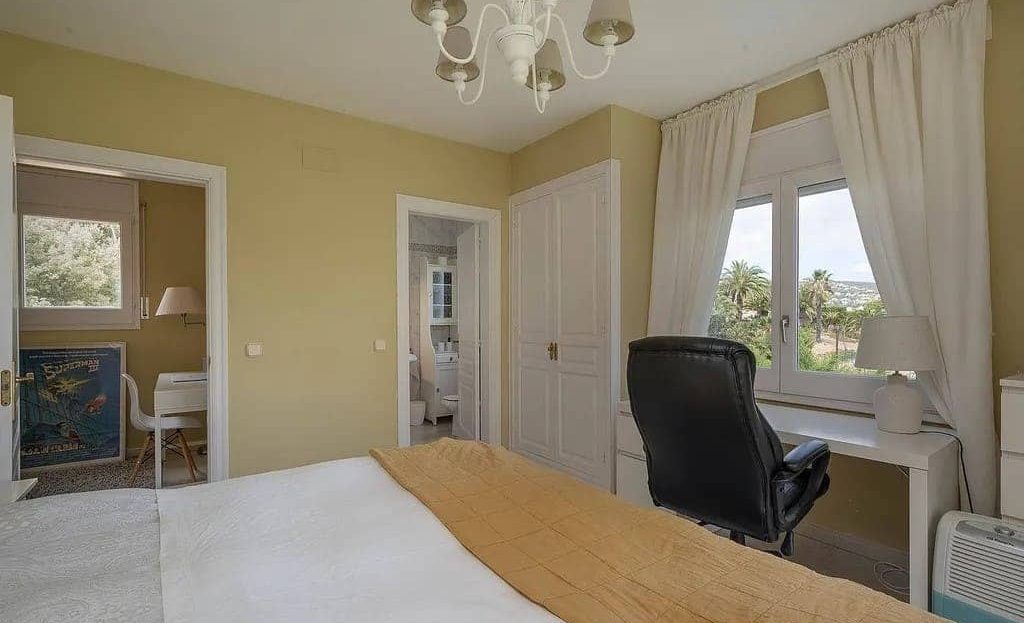 Спальня с рабочим местом и окрашенными стенами.