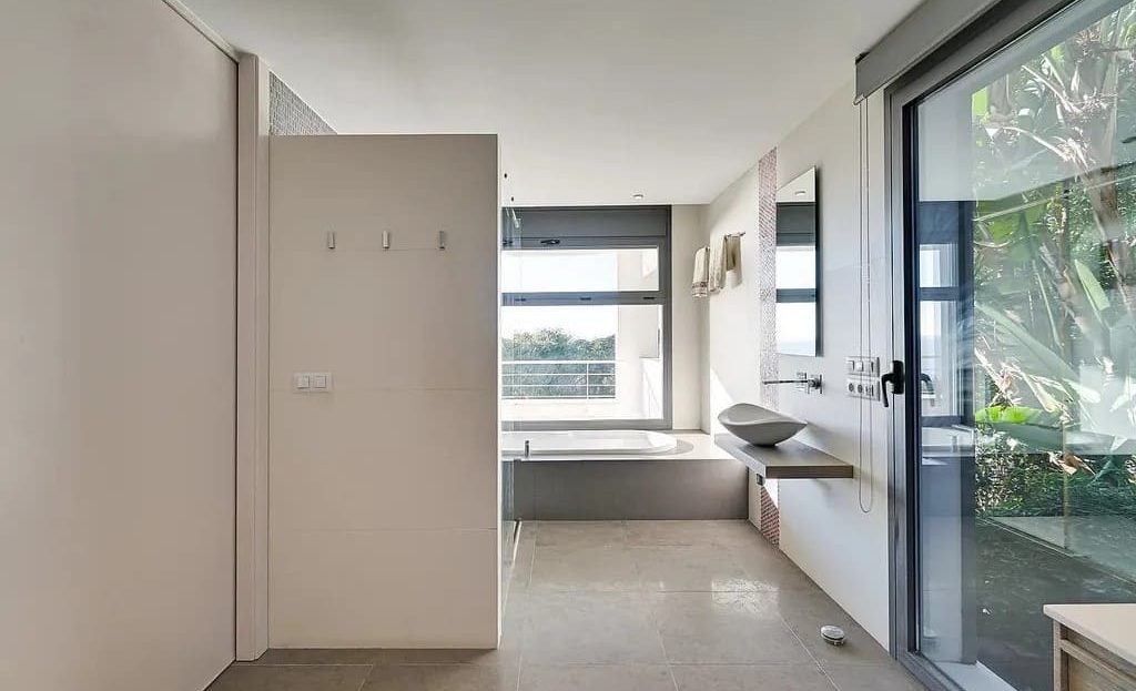 Главная ванная комната с панорамными окнами и современной отделкой