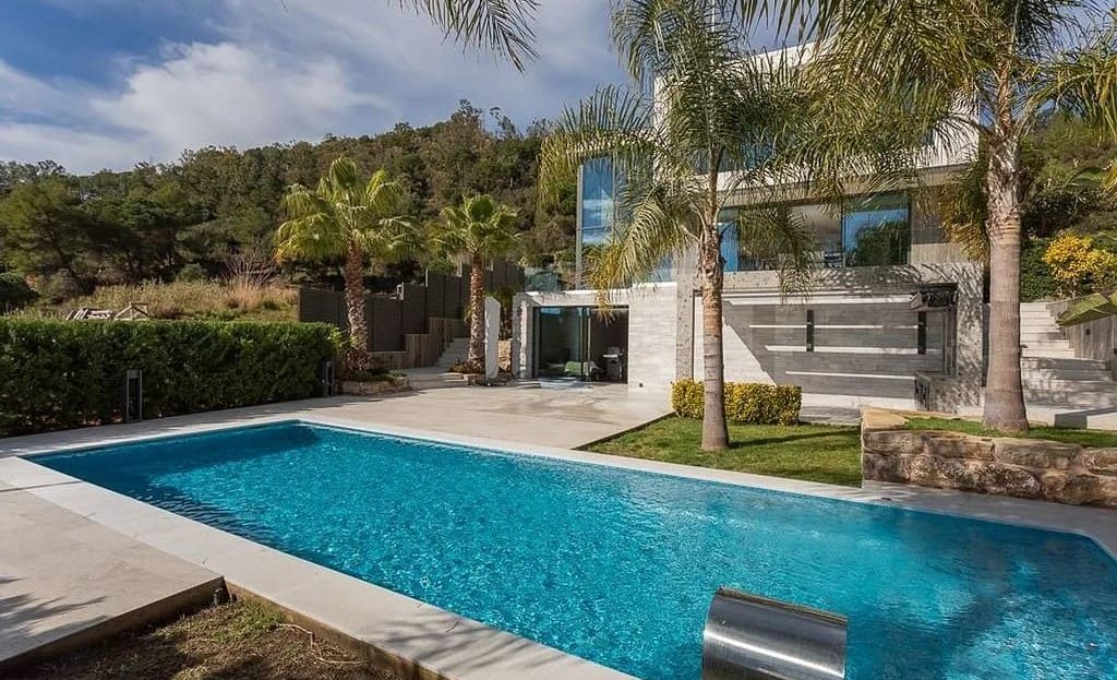 Частный бассейн виллы с зонами отдыха и садом