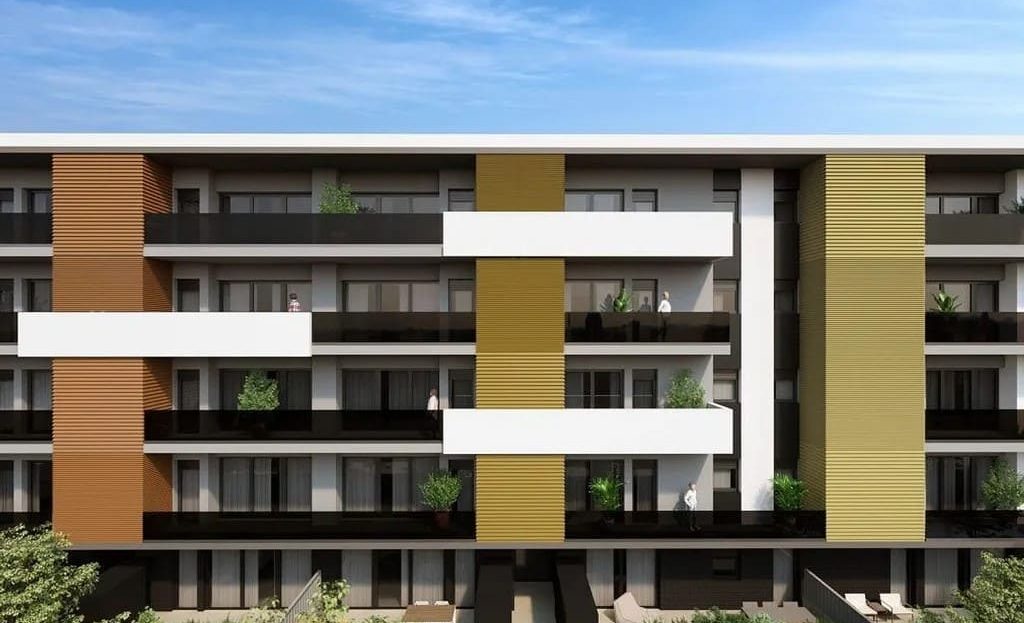 Современный жилой комплекс с балконами и зелёными акцентами на фасаде