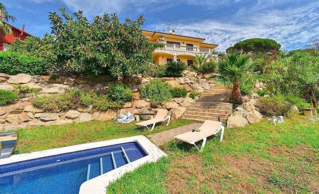 Бассейн и сад с видом на виллу.