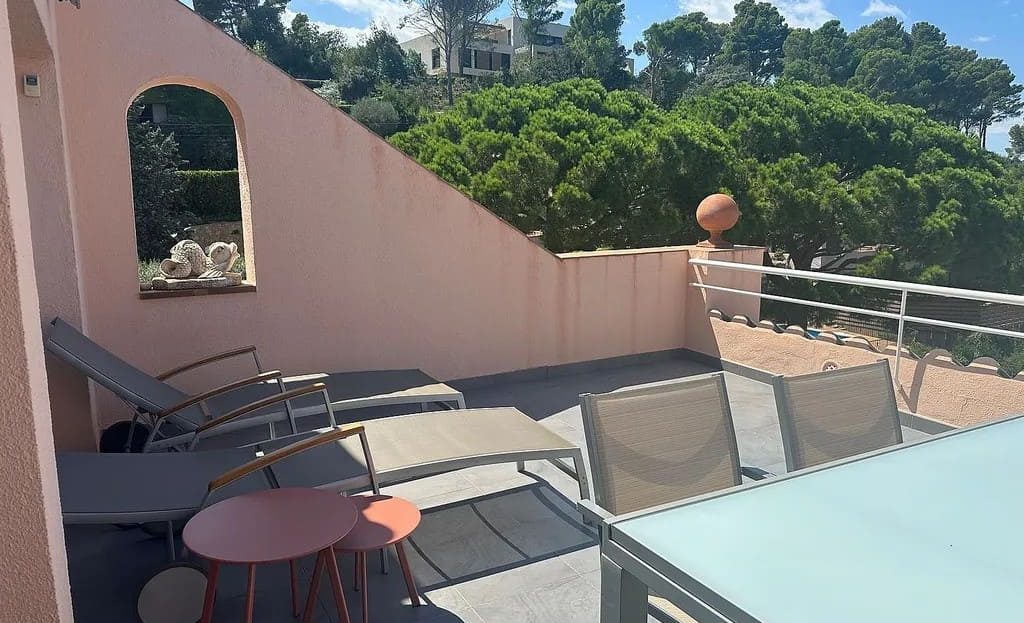 Терраса с зоной отдыха и видом на зелёные холмы и море.