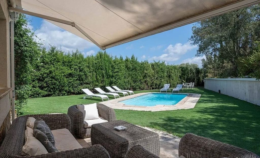 Зона отдыха под тентом с видом на бассейн.