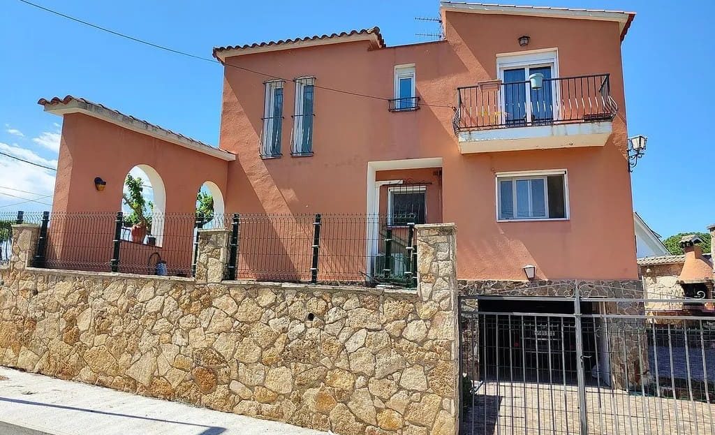 Дом с каменным забором и въездными воротами.