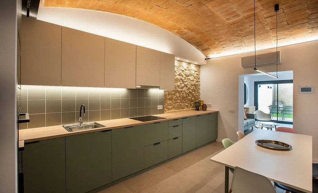 Современная кухня с встроенной техникой и длинной рабочей поверхностью.