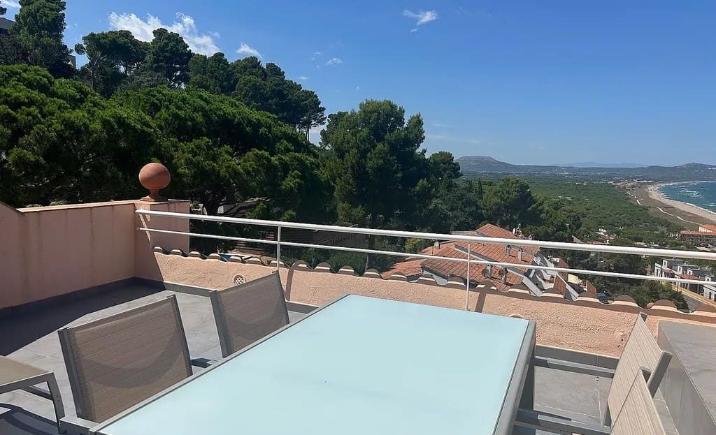 Обеденная зона на террасе с видом на море и прибрежные склоны.