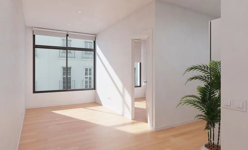 Пространство студии с большим окном, деревянным полом и зоной перехода между комнатами.