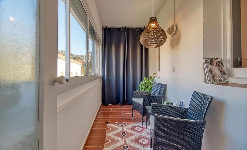 Закрытая терраса со стеклянными окнами и зоной отдыха.