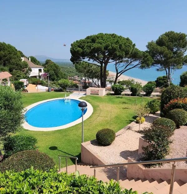 Общий бассейн и ухоженный сад с видом на море.