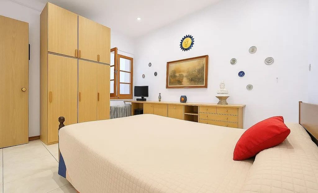 Основная спальня с двухместной кроватью, шкафами и светлым интерьером.