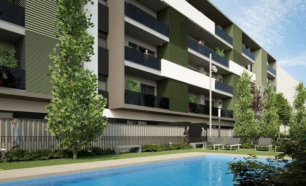 Вид на бассейн и фасады комплекса с зелёными зонами.