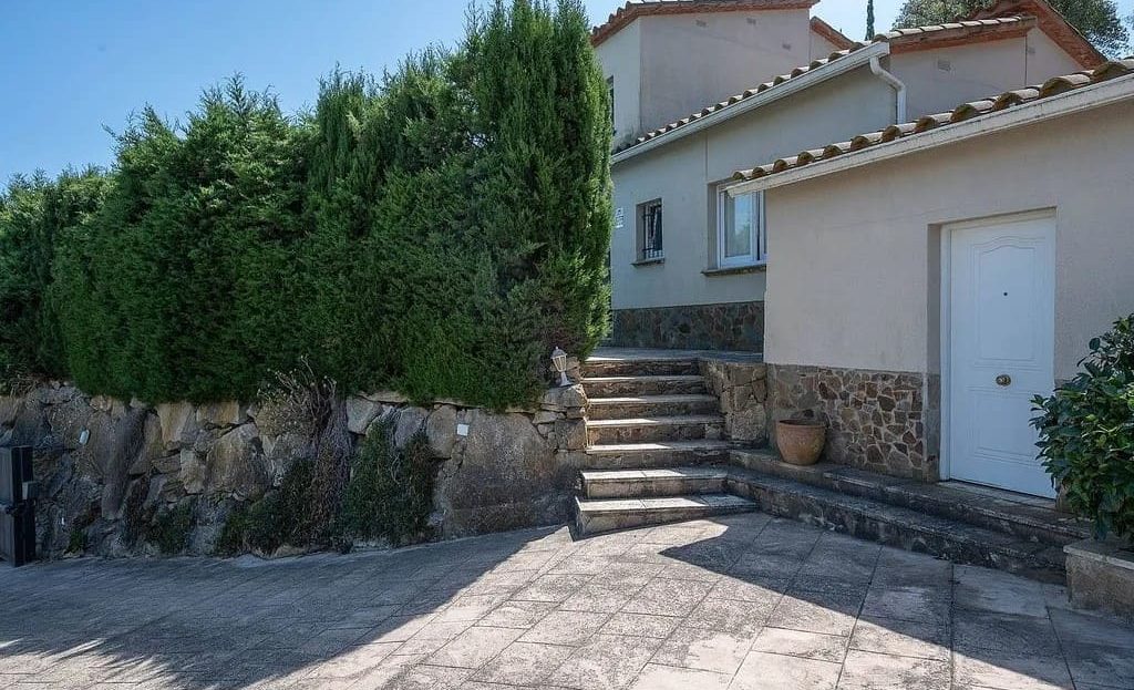 Входная зона с парковкой и зелёной изгородью.