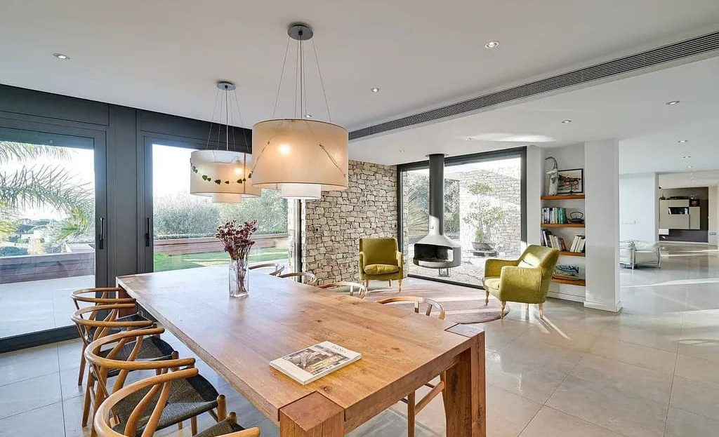 Просторная столовая с большими окнами и видом на сад