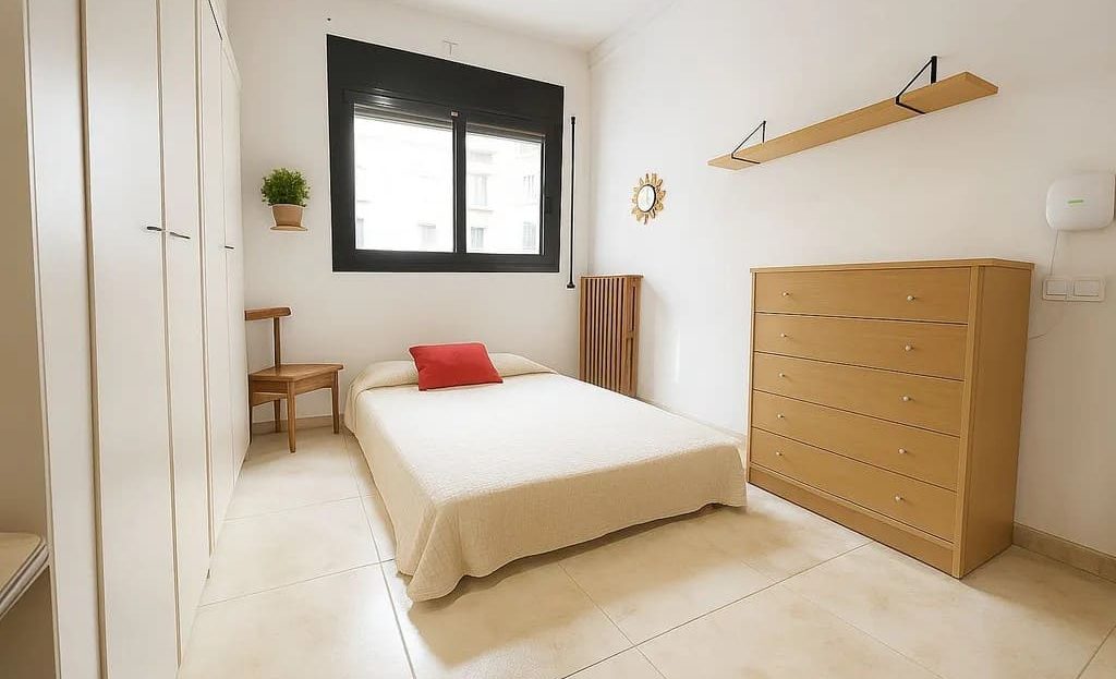 Вторая спальня с кроватью, шкафом и окном с естественным освещением.