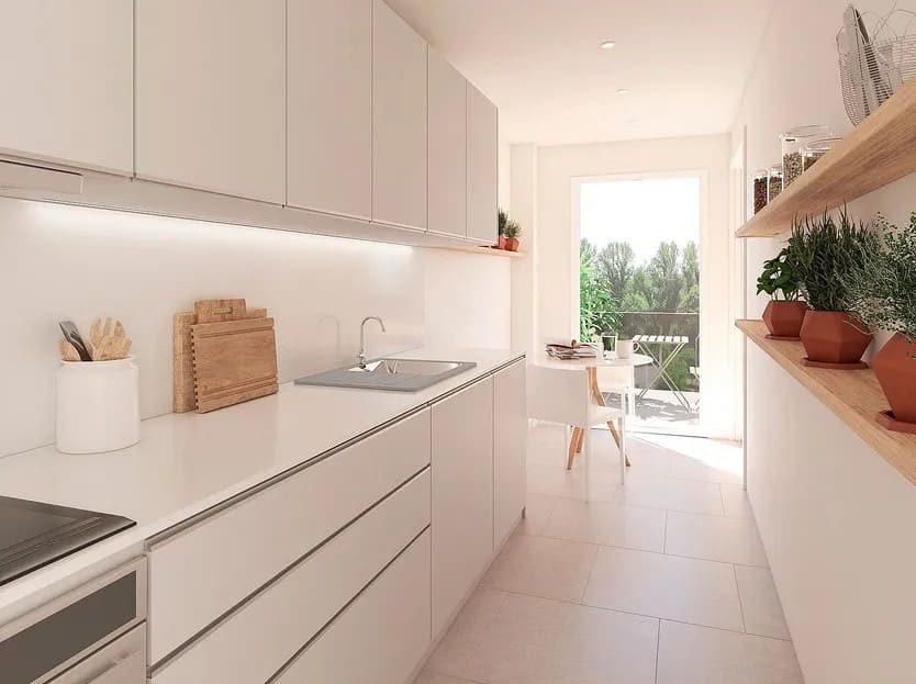 Современная кухня с белыми фасадами и естественным освещением