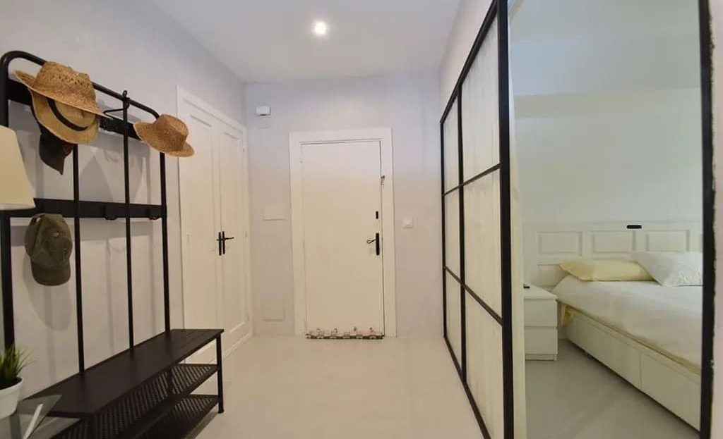 Прихожая с гардеробной зоной и современным освещением.