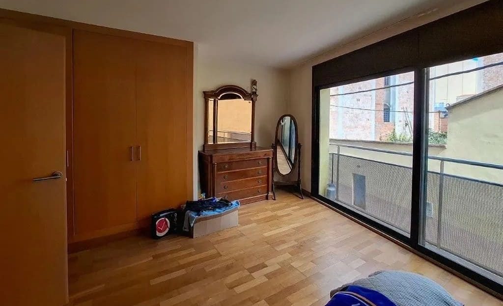 Спальня с деревянными шкафами и выходом на балкон.