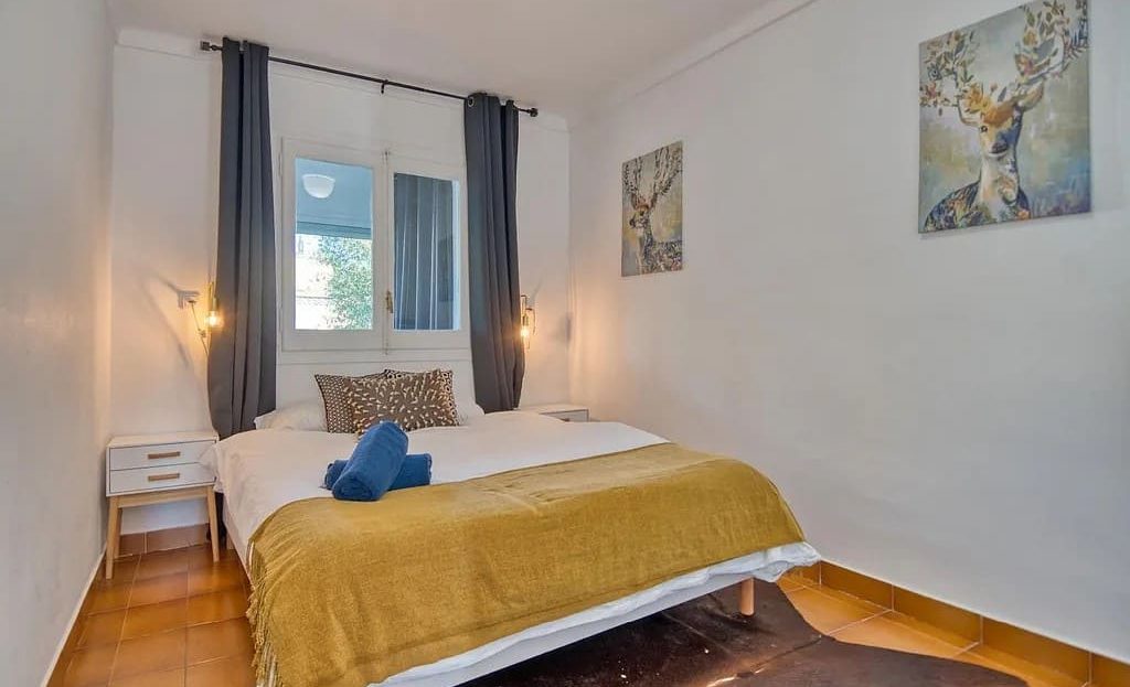 Светлая спальня с двуспальной кроватью и современным декором.