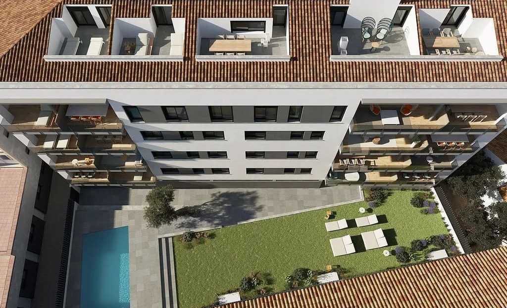 Аэрофотоснимок здания с террасами, бассейном и садом.