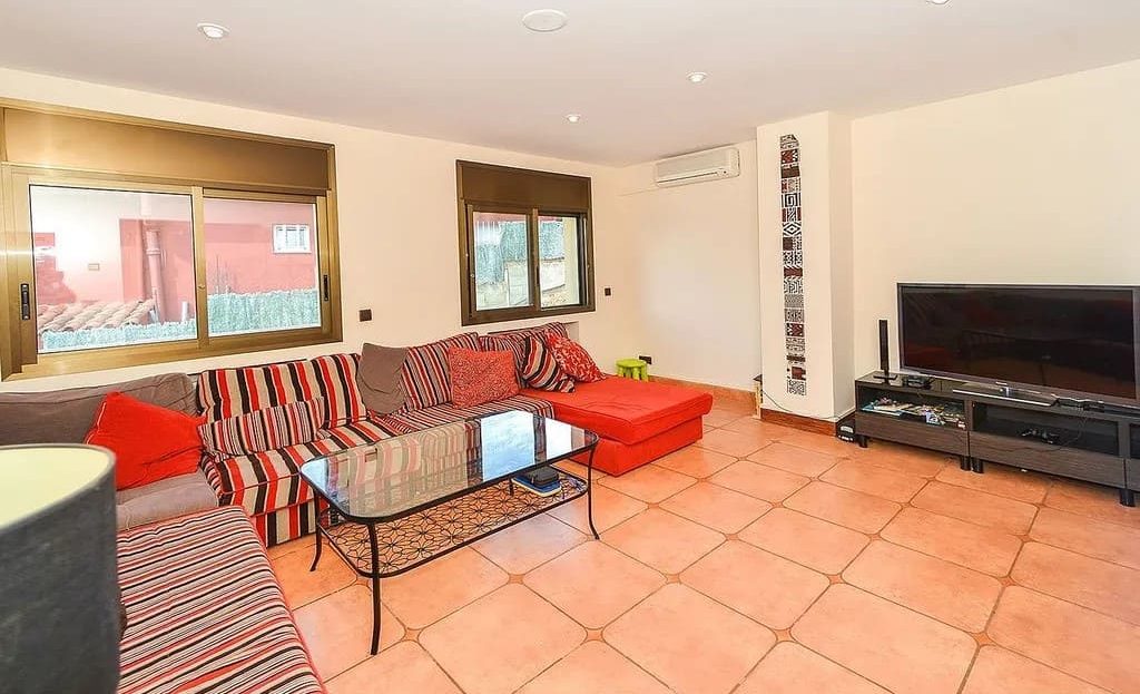 Гостиная с большим диваном и телевизором.