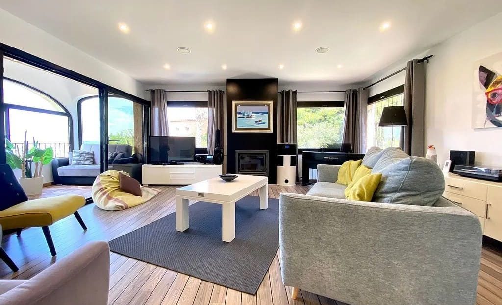 Светлая гостиная с видом на сад и панорамными окнами.