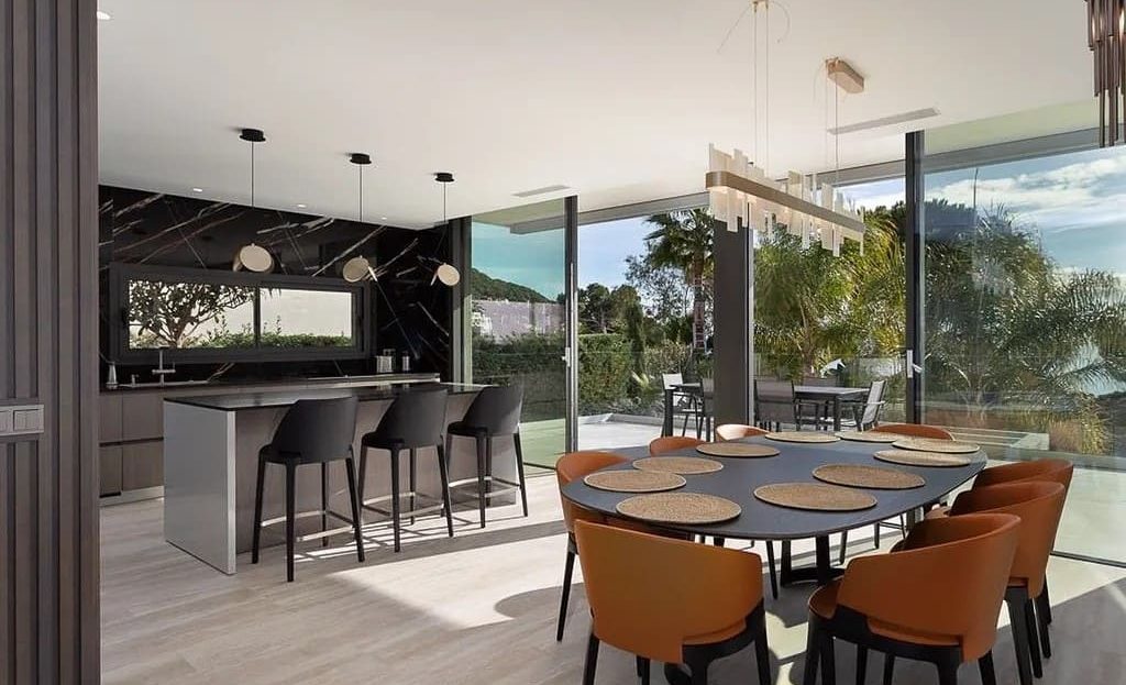 Современная кухня и столовая с панорамным видом на сад