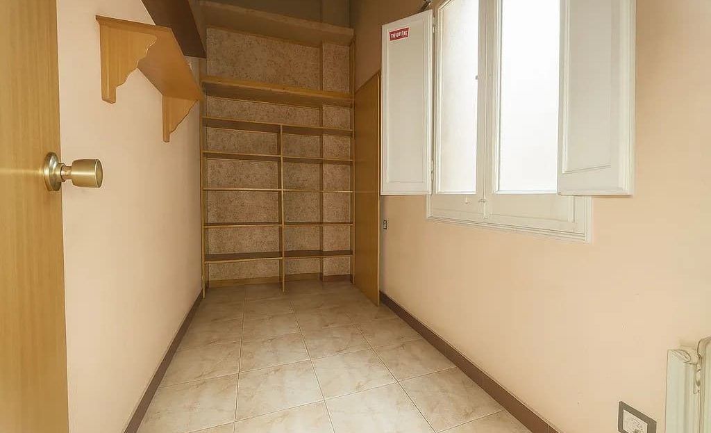 Кабинет или вспомогательная комната с окном и встроенными полками.