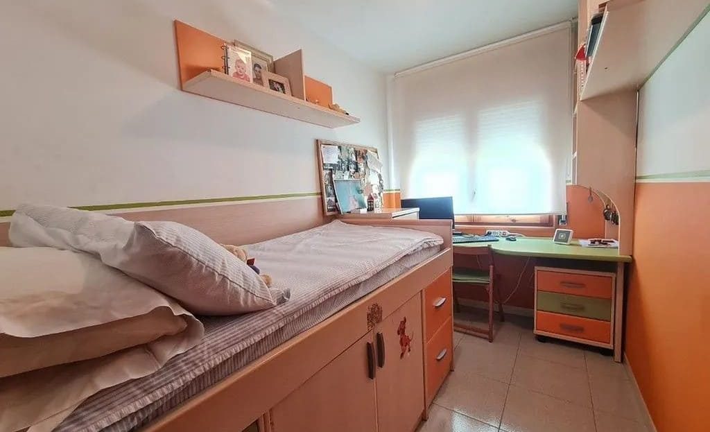 Одноместная спальня с рабочей зоной и окном.