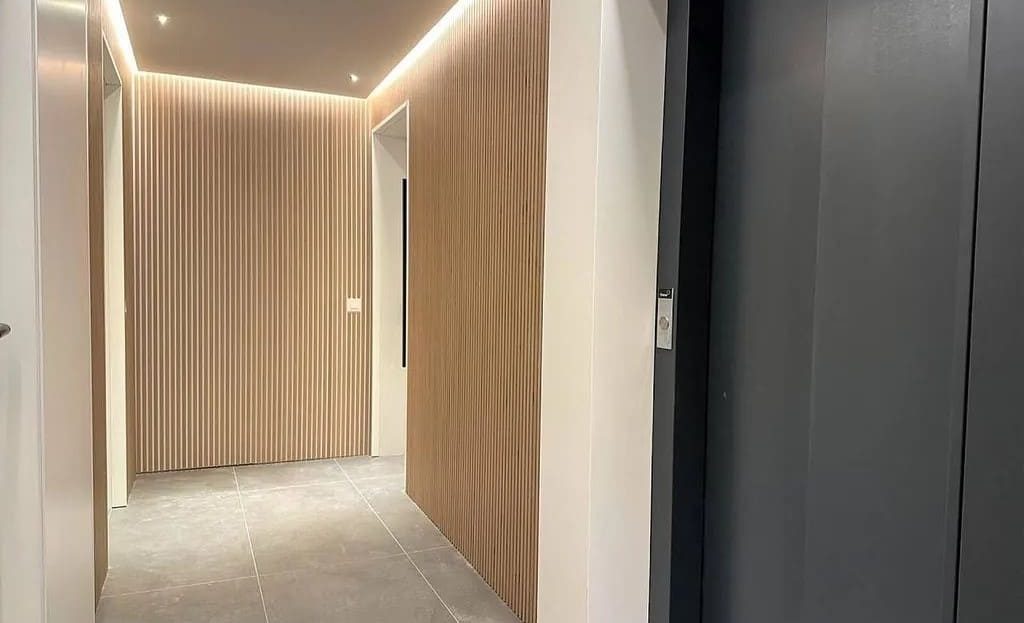 Коридор с современным освещением и отделкой в светлых тонах.