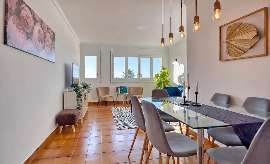 Столовая зона с большим обеденным столом и подвесными светильниками.