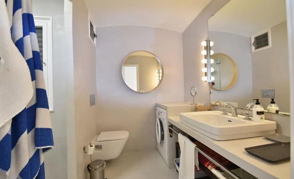 Ванная комната с двойной раковиной, зеркалами и душем.