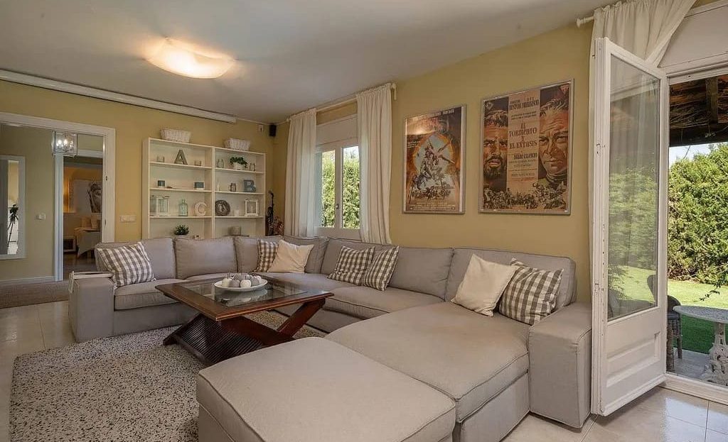 Светлая гостиная с угловым диваном и видом на сад.