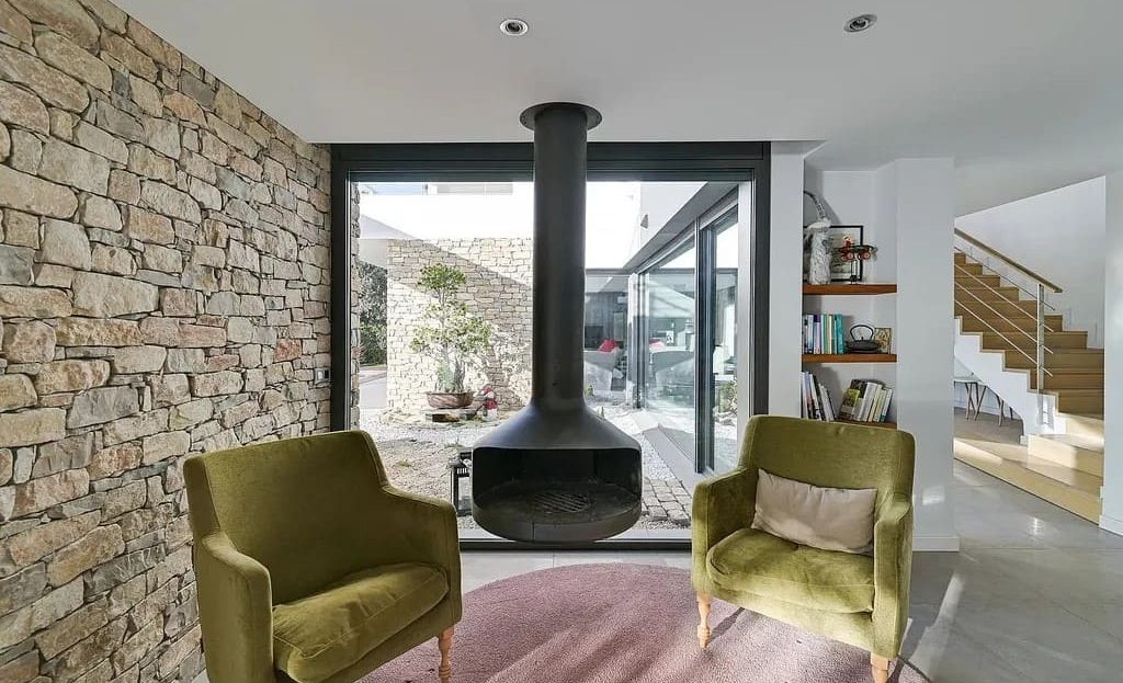 Гостиная с камином и панорамными окнами с видом на море