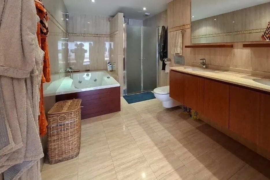 Ванная комната с душевой, двойной раковиной и встроенными шкафами