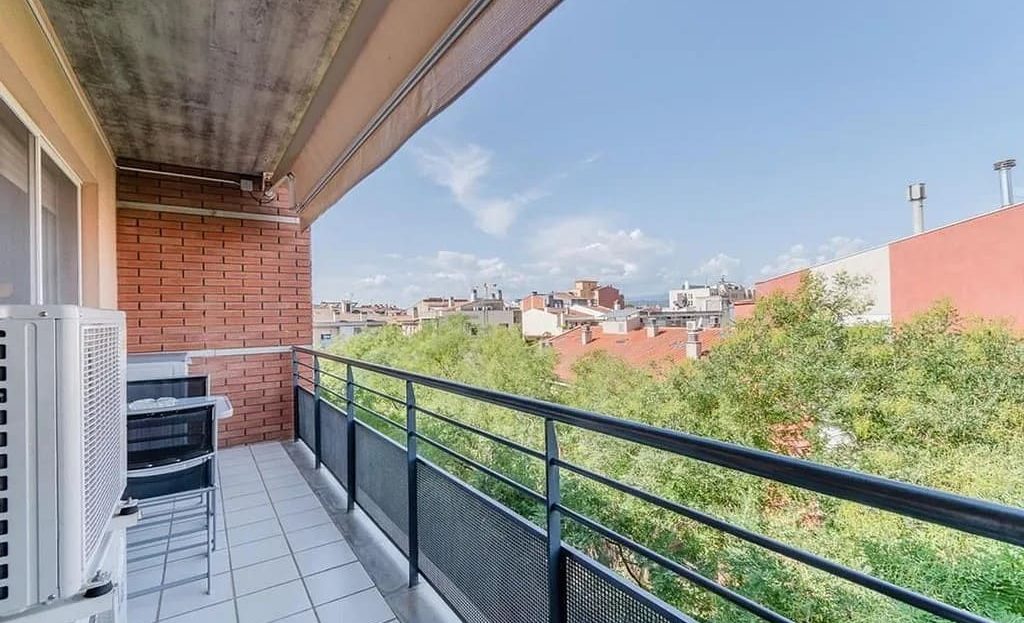 Балкон с видом на город и зелёные насаждения.