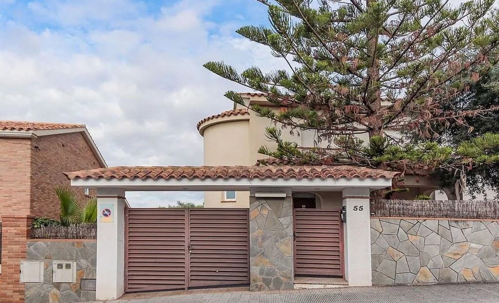 фасад дома в Сегур-де-Калафель с гаражом и каменным забором