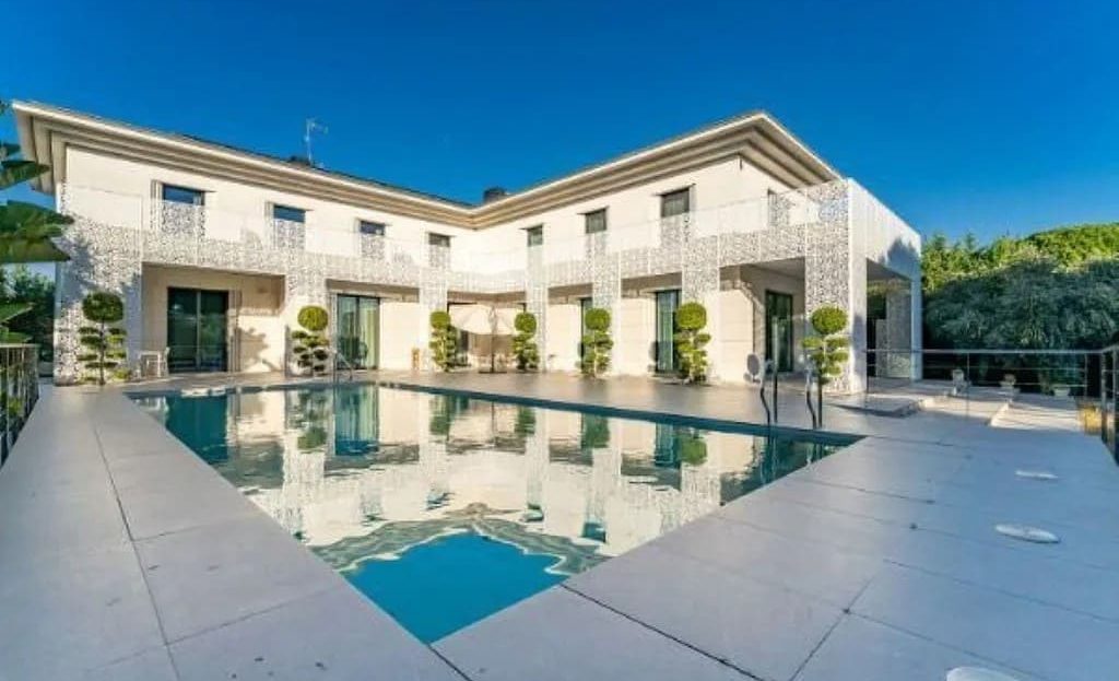 Вид фасада виллы с бассейном на переднем плане