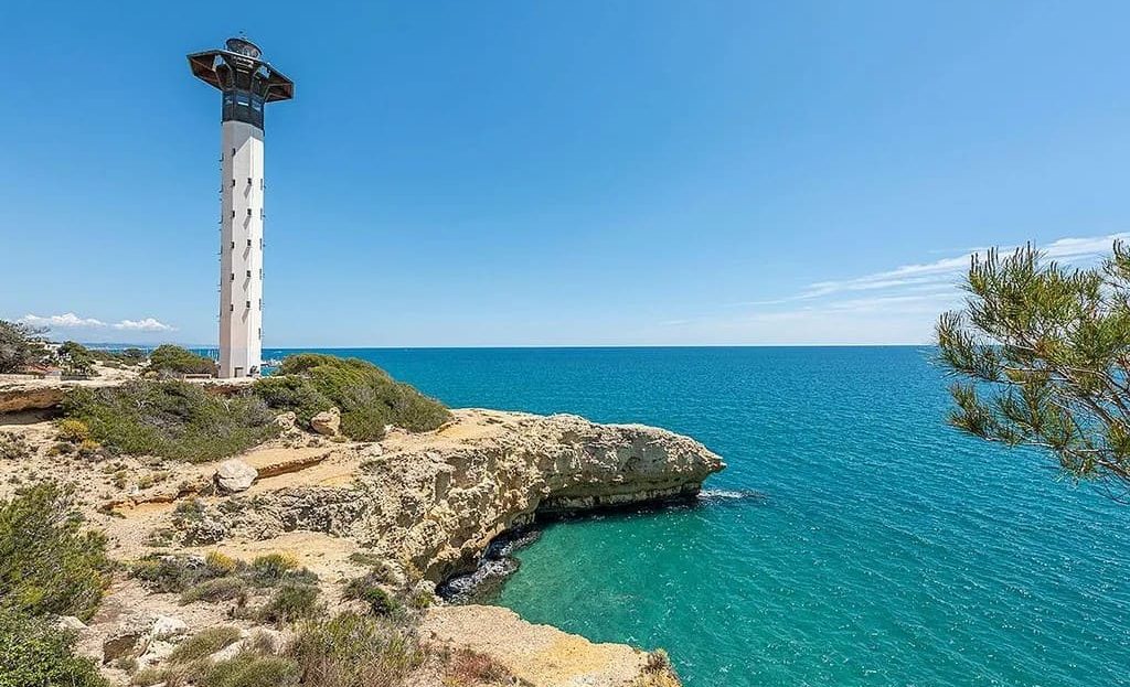 Маяк Торредембарра на скалистом побережье Средиземного моря рядом с участком