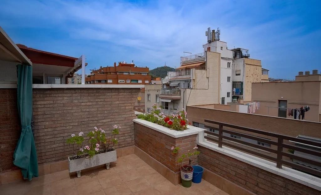 Терраса пентхауса с видом на город и кирпичными ограждениями