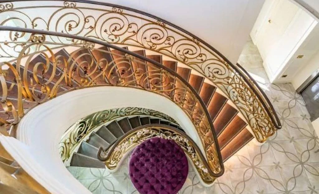 Спиральная лестница с коваными перилами в интерьере