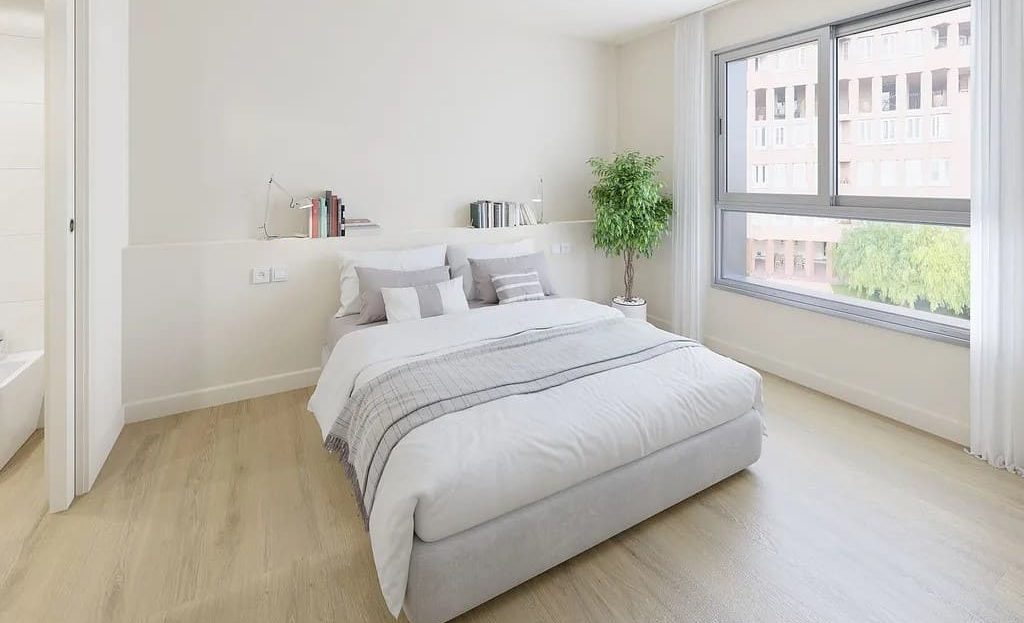 Главная спальня с двуспальной кроватью и большими окнами