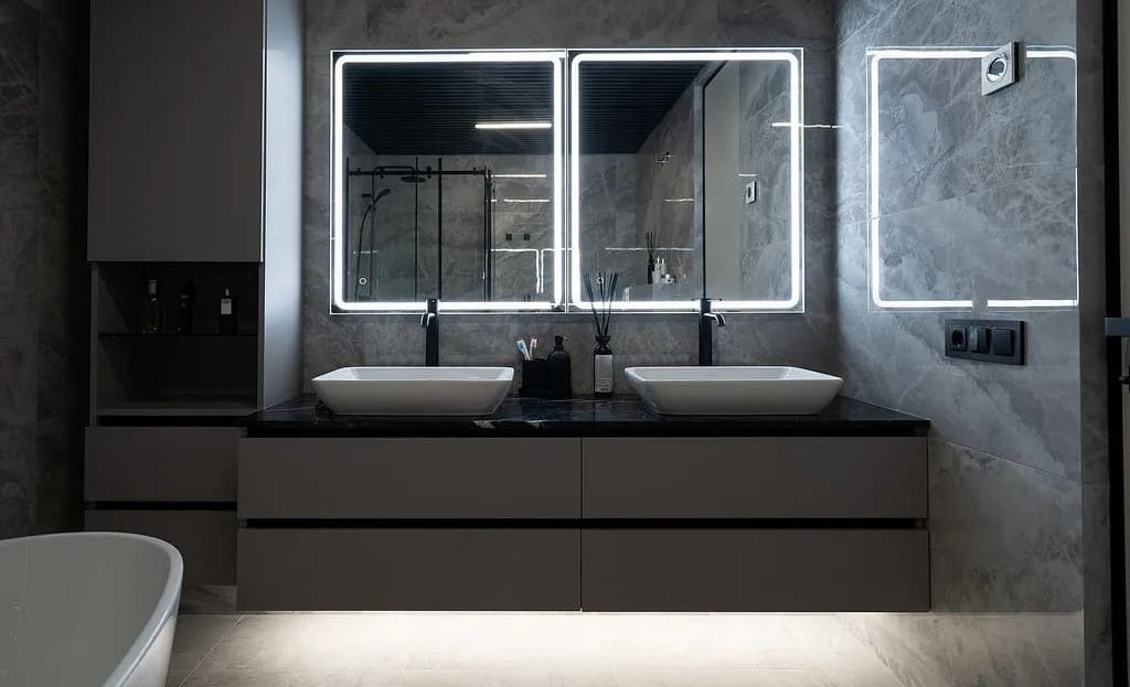 Ванная комната с двойной раковиной и подсветкой зеркал.