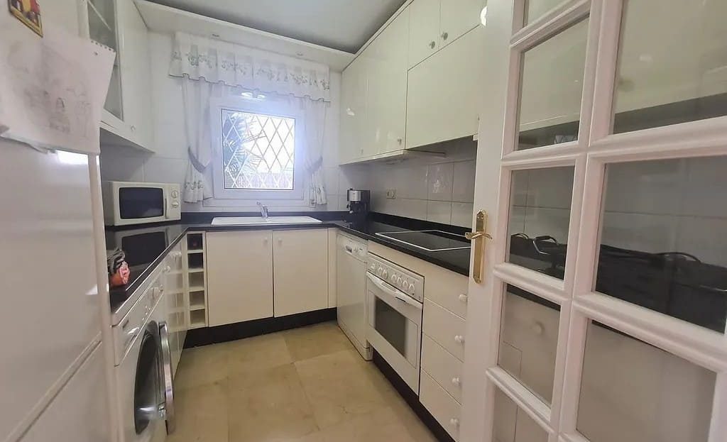 Отдельная оборудованная кухня с белыми фасадами.