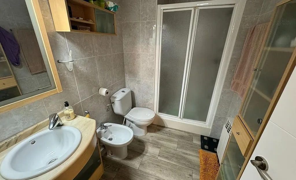 Ванная комната с душевой кабиной, раковиной и туалетом.