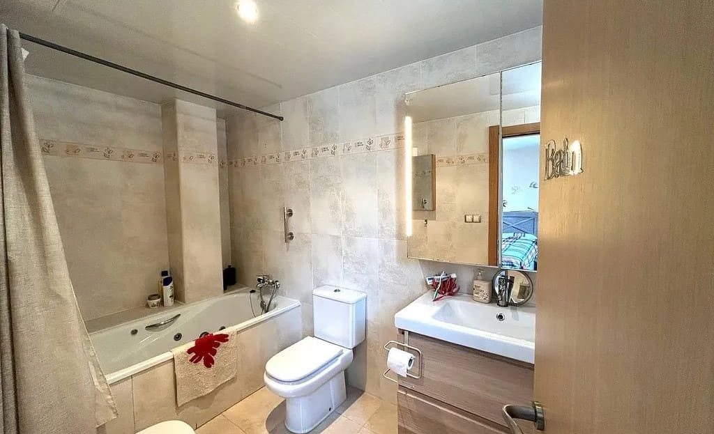 Ванная комната с ванной, раковиной и туалетом.