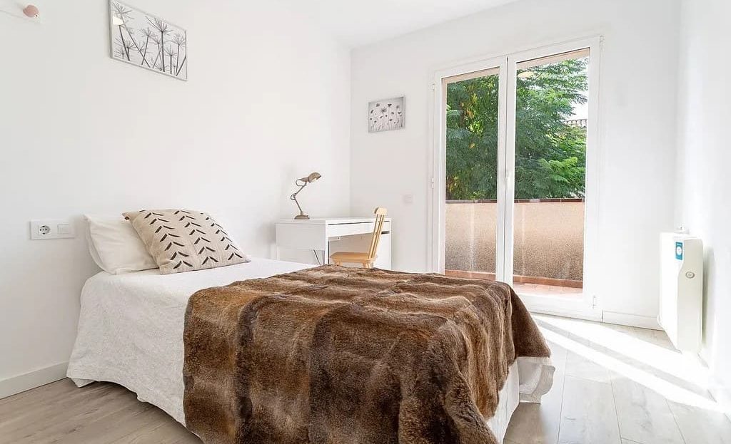 Вторая спальня с двуспальной кроватью и светлым интерьером