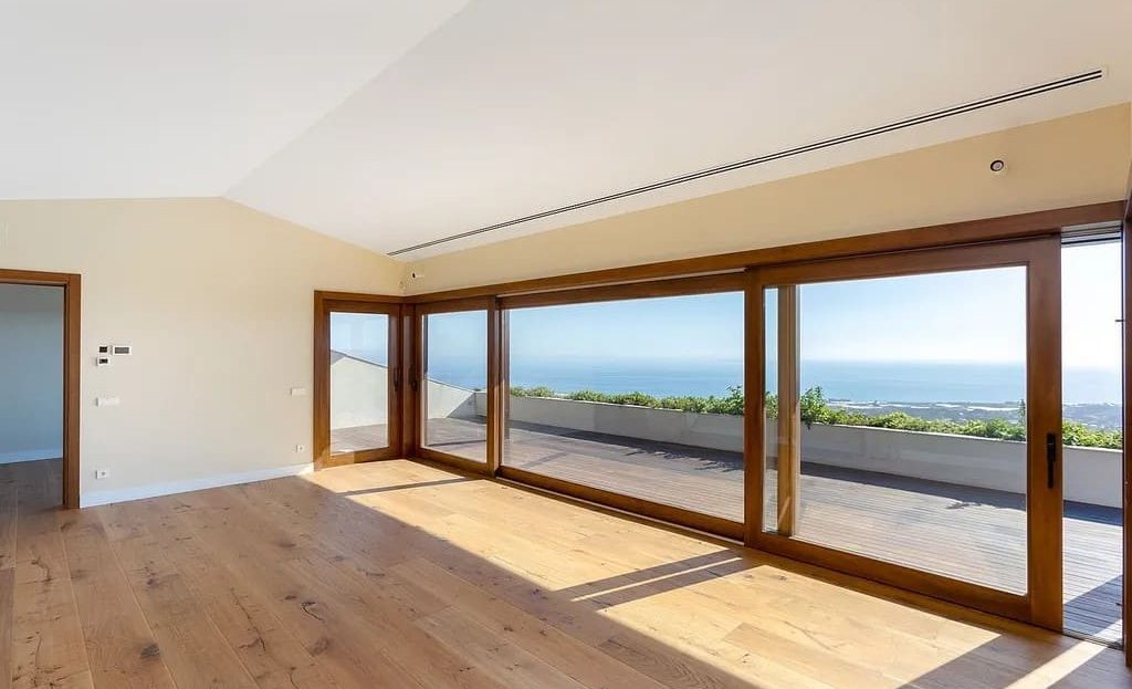 Светлая комната с большими окнами и видом на побережье.
