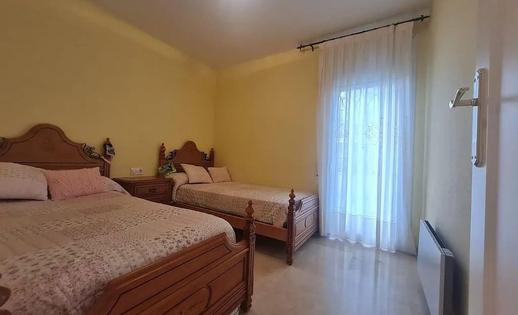 Вторая спальня с двумя кроватями и светлым интерьером.