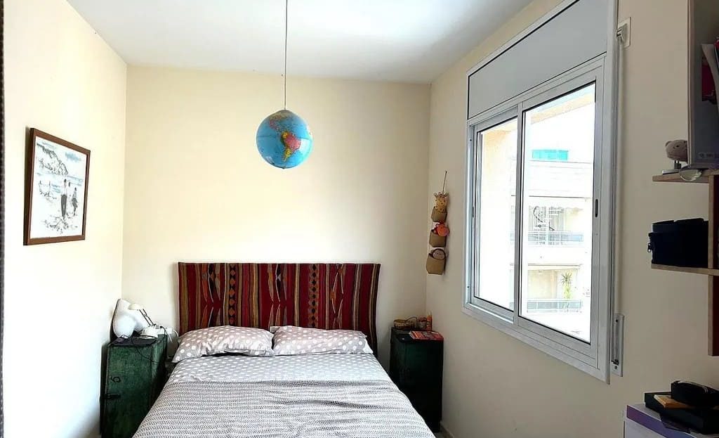 Вторая спальня с двуспальной кроватью и окном.