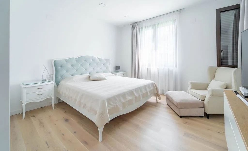 Главная спальня с большой кроватью и окнами